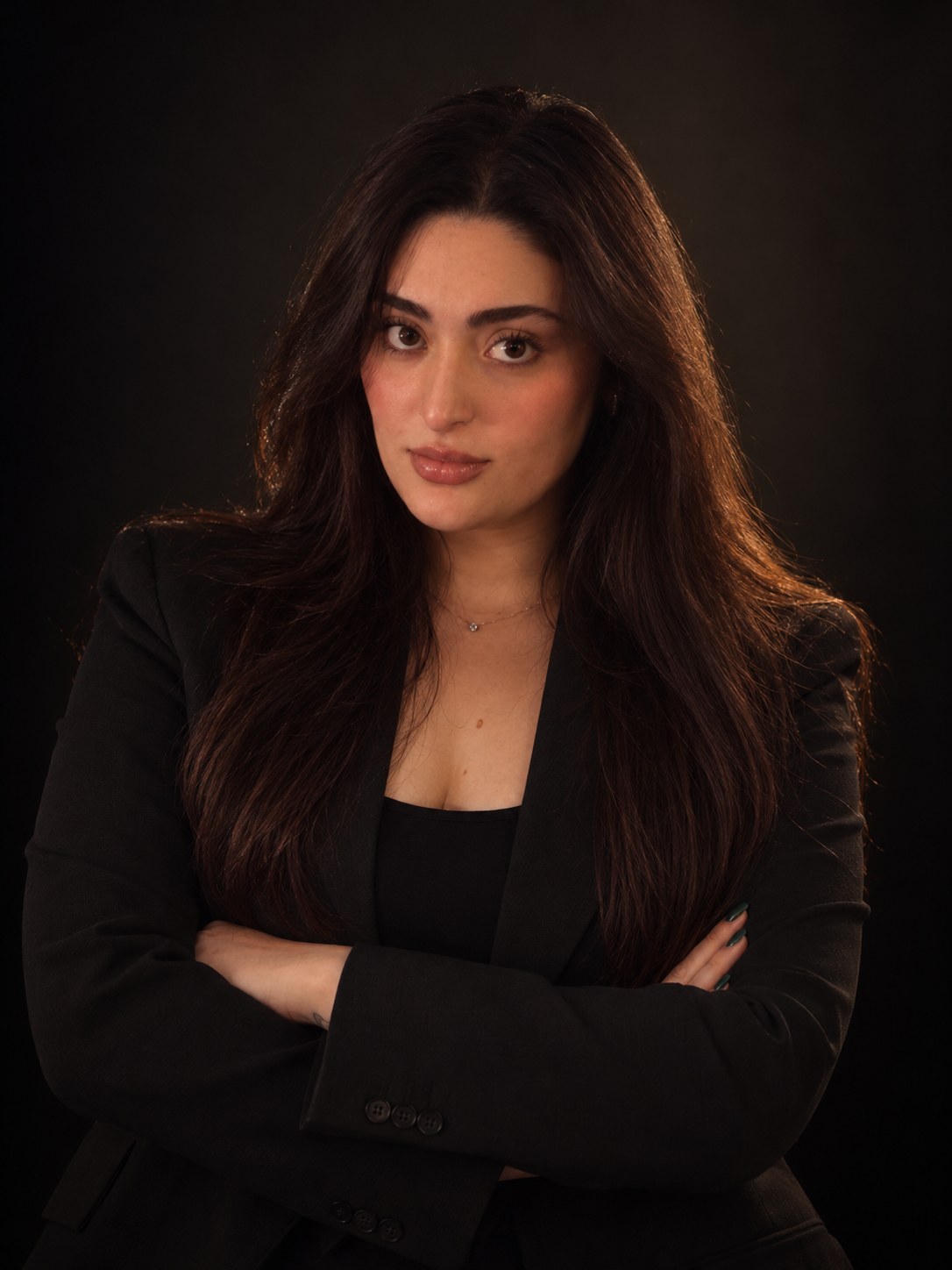 Portrait of Bianca Silva with her arms crossed, in a black blazer